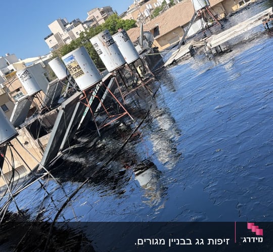 גג עם דודי שמש ואיטום בזפת שחורה